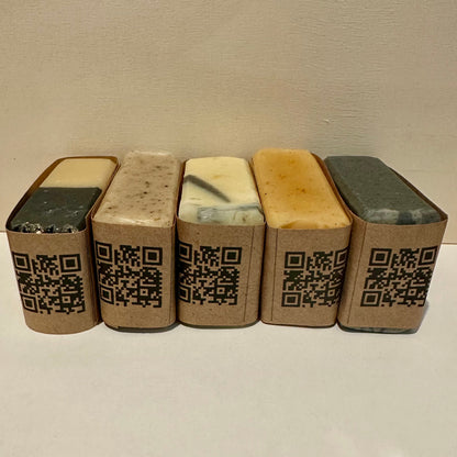 Five rectangular soap bars with QR codes on a neutral background